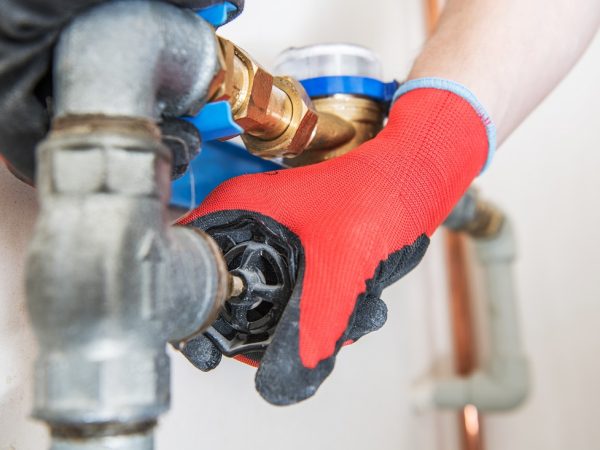 Residential Water Pipeline Valve Residential Water Pipeline Valve Closing. Plumbing Industry Concept. Caucasian Plumber Worker.